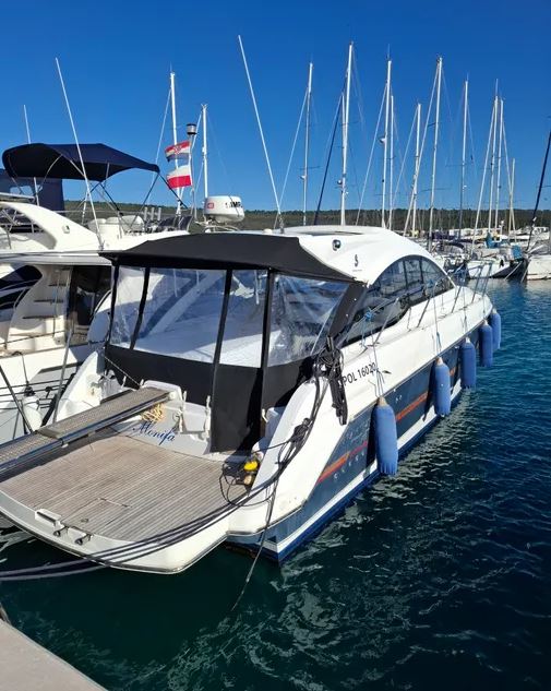 Sailing elegantly, Monifa showcases its sleek hull and impressive sails against a clear blue sky.