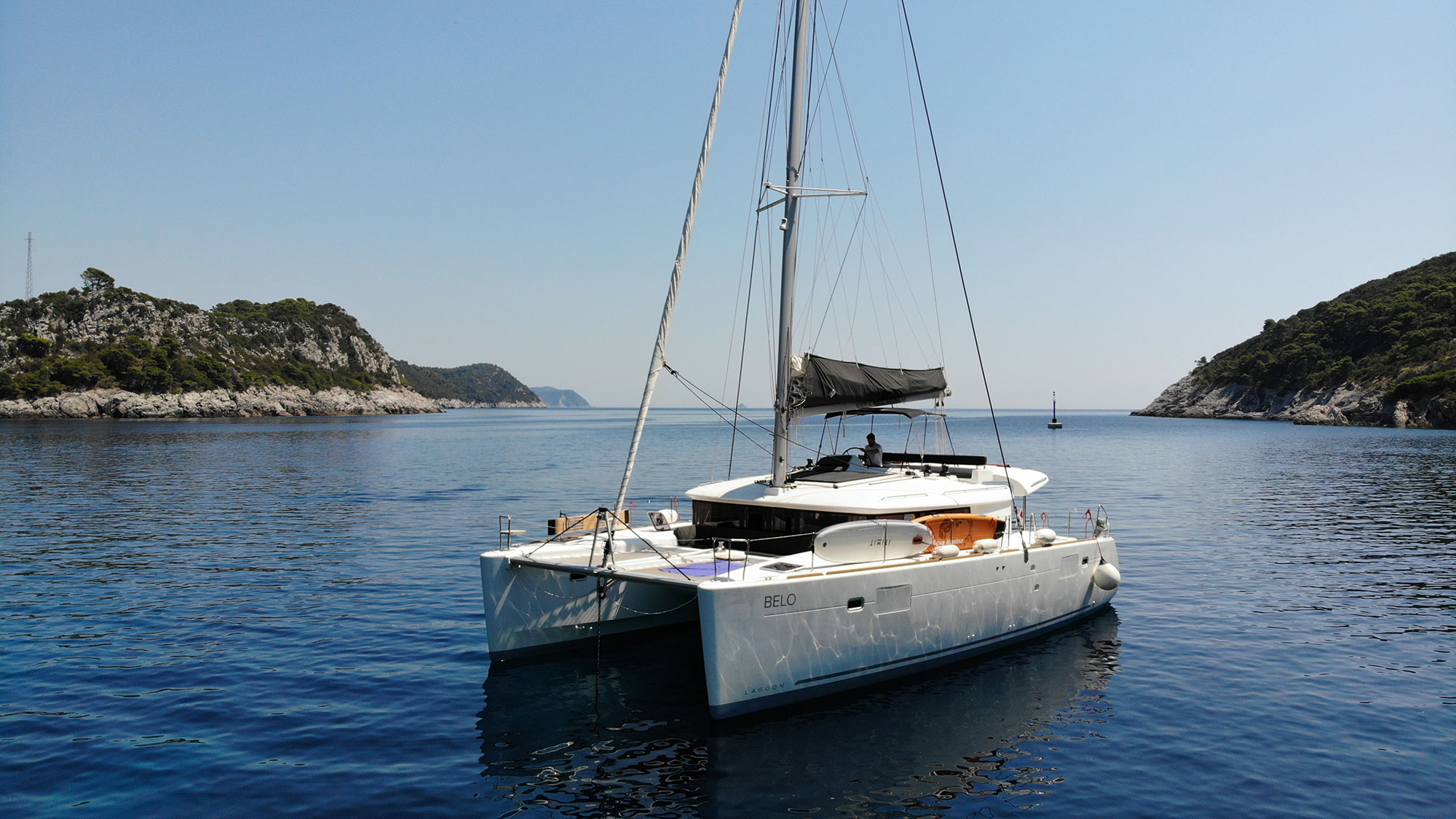 Sleek profile of the Belo yacht gliding through tranquil waters, showcasing its elegant design.