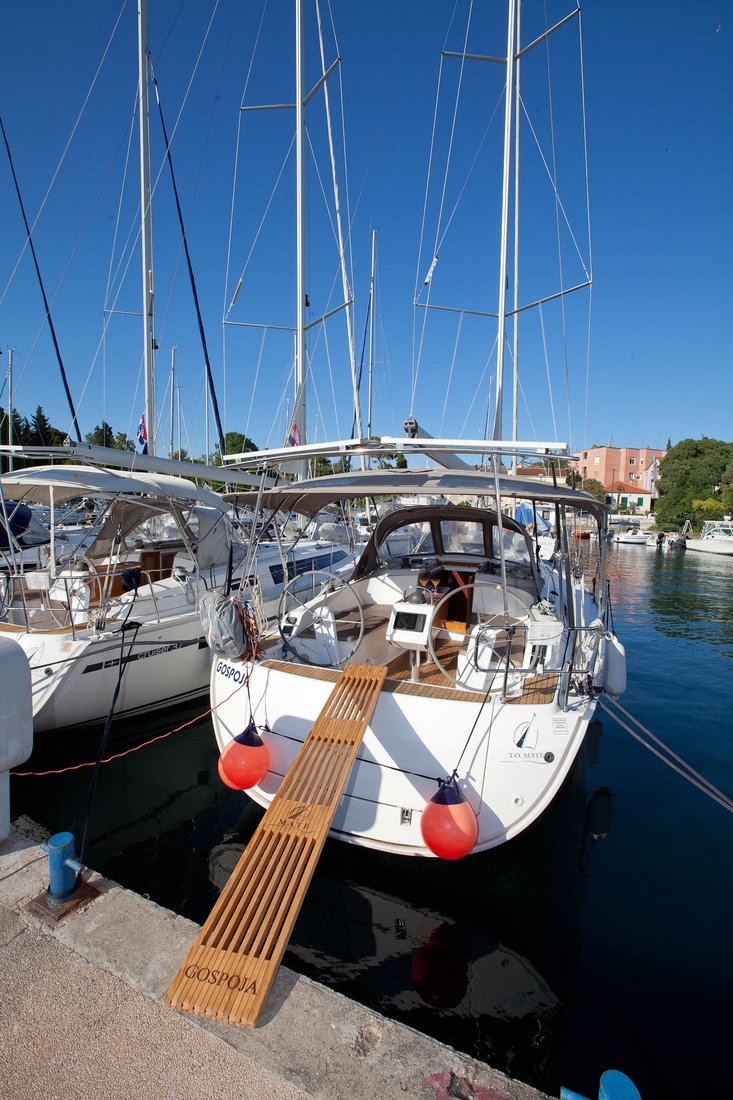 Gospoja docked in a serene marina, showcasing its elegant lines and inviting atmosphere.