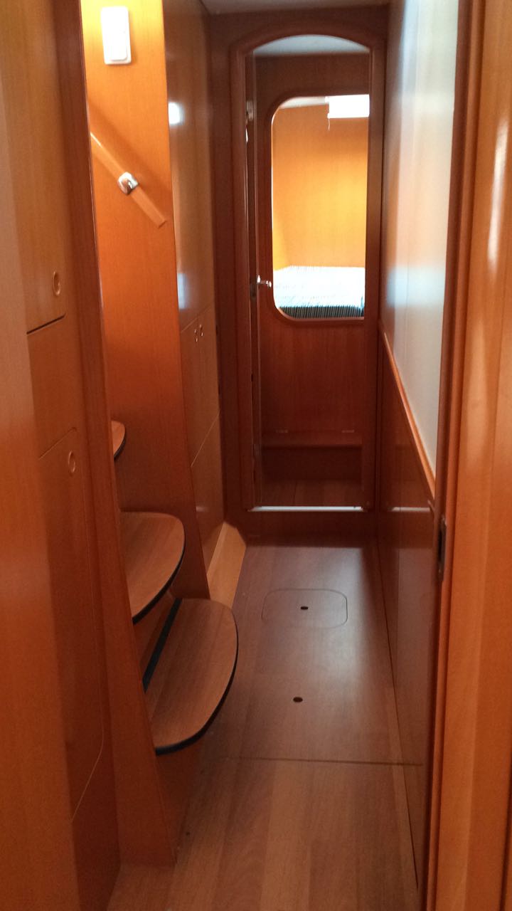 Elegant interior staircase leading to cozy cabin on the Vega yacht, featuring warm wood finishes.