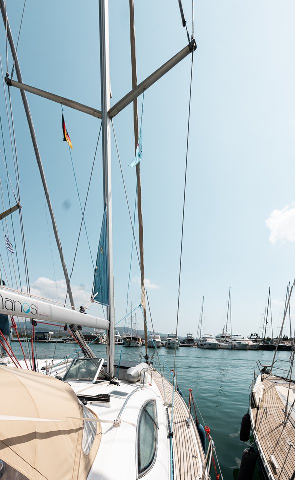 Elegant profile of Evita docked in a vibrant marina, showcasing its sleek lines and sails.