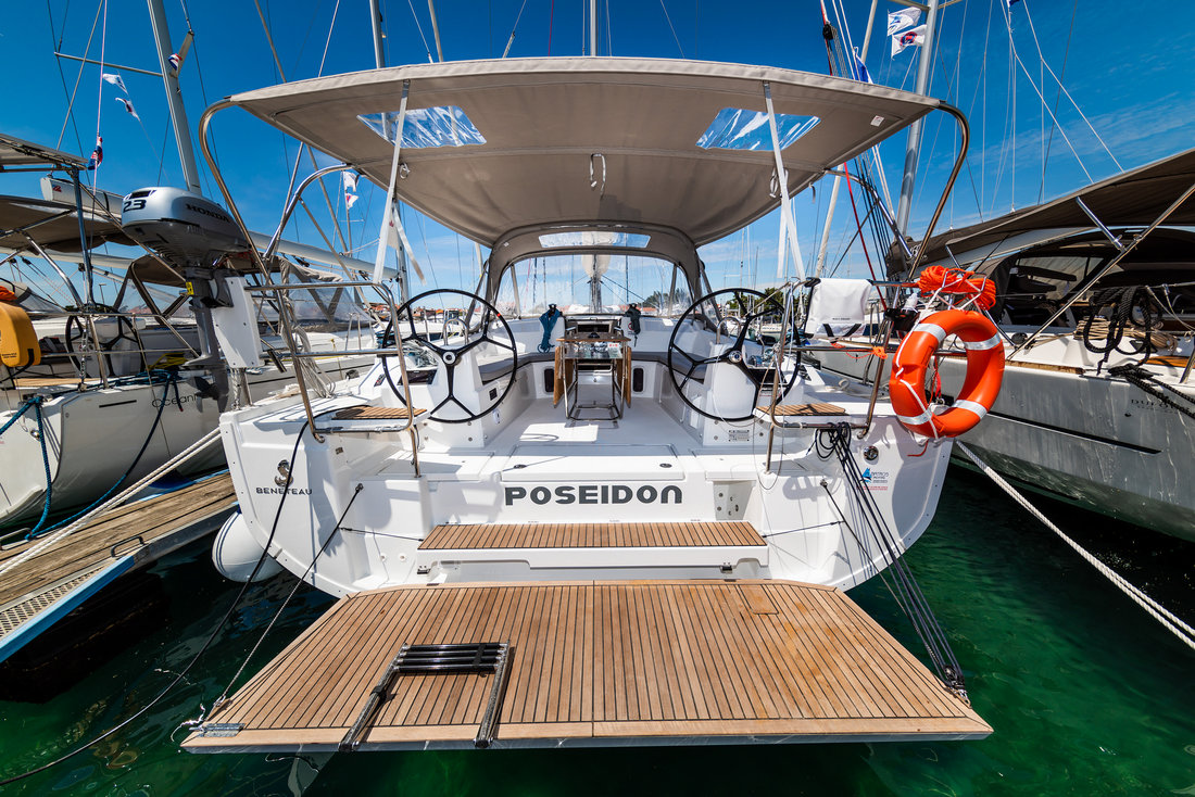 Sleek stern view of Poseidon showcasing elegant teak deck and dual steering wheels.