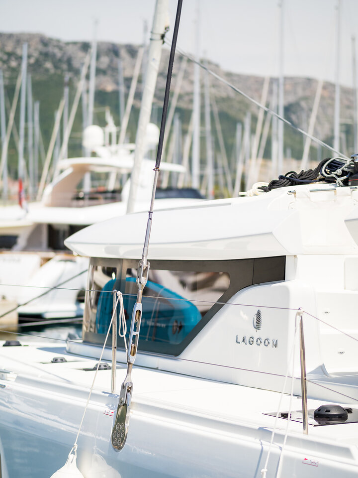 Sleek profile of Madame El Grande docked among luxury yachts in a serene marina.