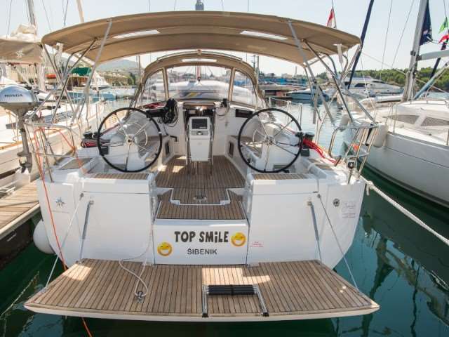 Sleek stern view of Top Smile showcasing dual steering wheels and elegant teak decking.