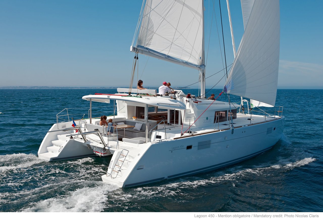 Sleek profile of Fo's sailing gracefully through azure waters with full sails.