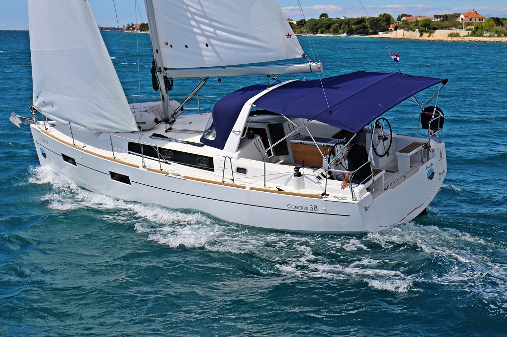 Sleek profile of Fede gliding through turquoise waters, showcasing elegant lines and vibrant sails.