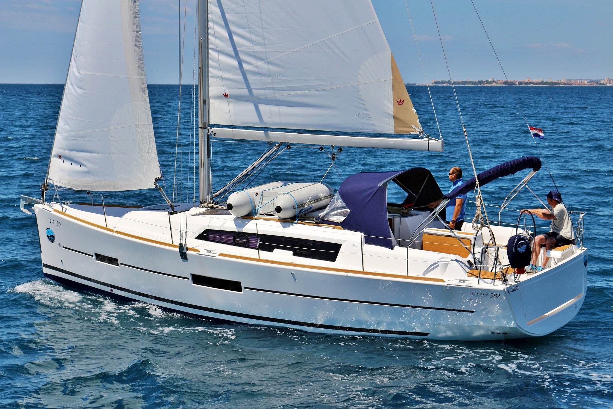 Sailing yacht Louise gliding gracefully through azure waters, showcasing elegant lines and sails.