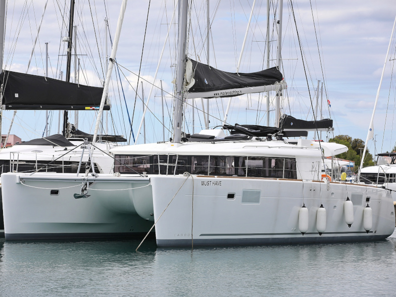 Elegant profile of the yacht "MUST HAVE" docked, showcasing its sleek hull and modern design.