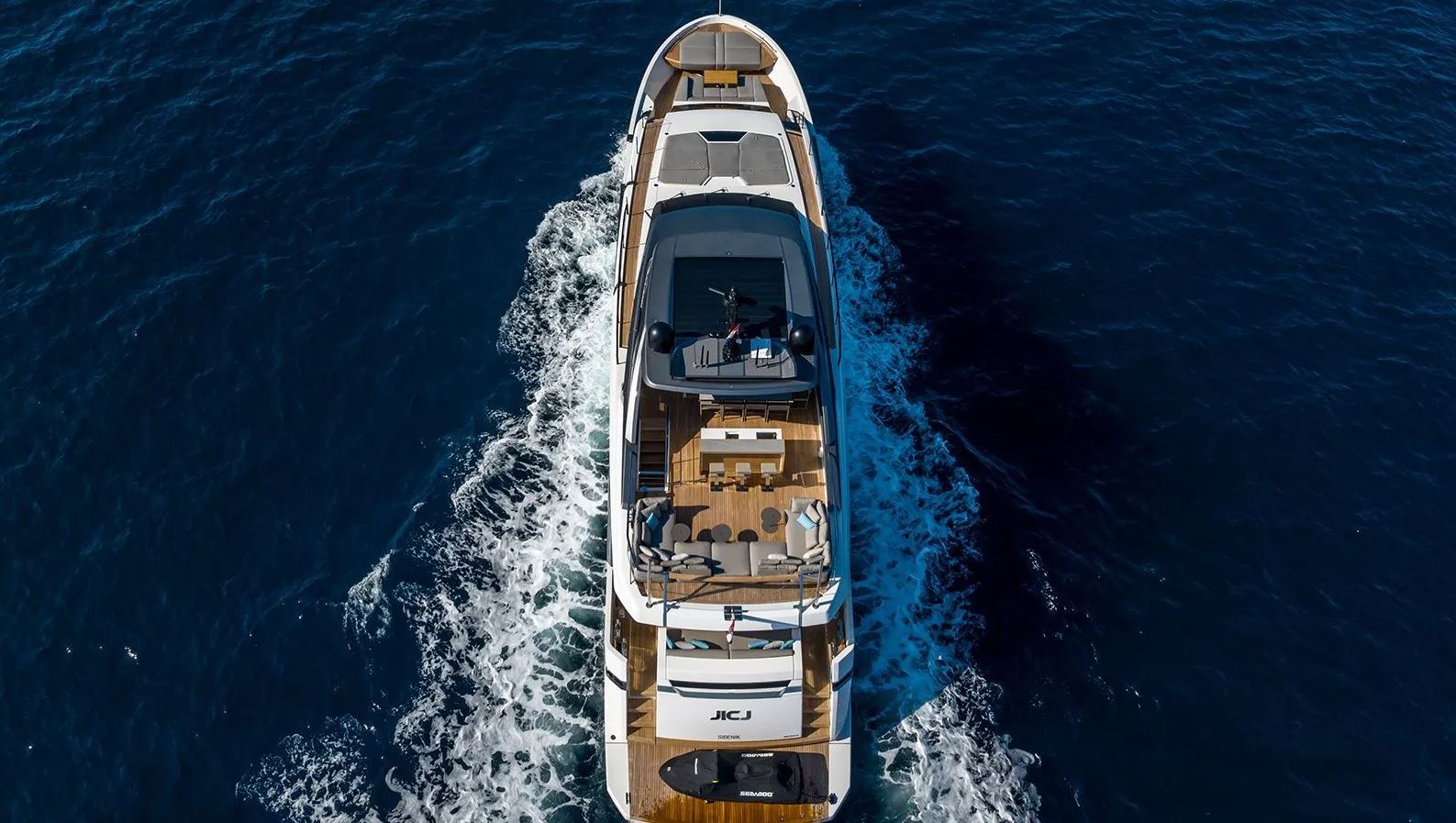 Sleek profile of JICJ cruising through azure waters, showcasing luxurious deck and amenities.