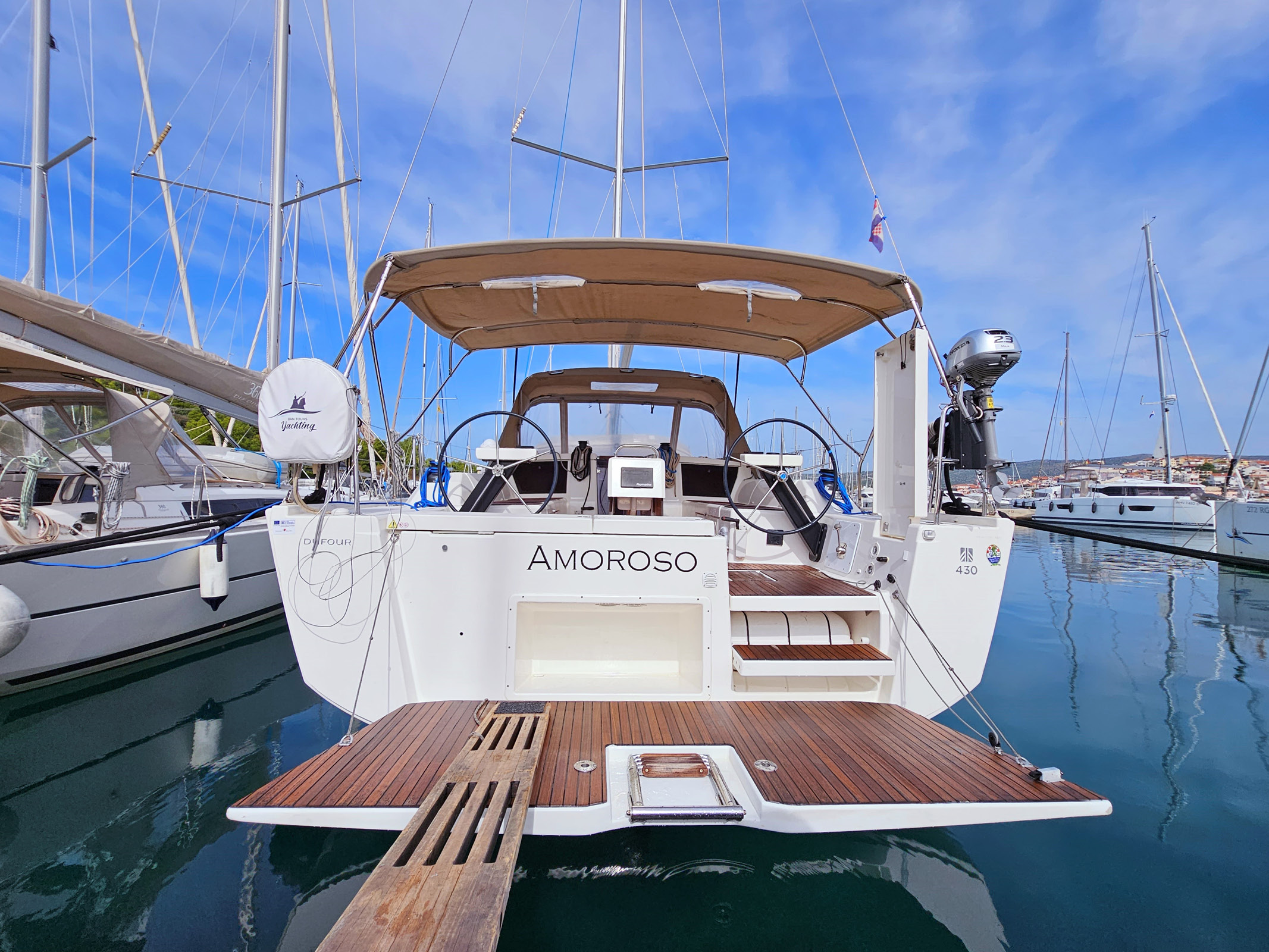 Amoroso's elegant stern showcases a sleek profile, inviting relaxation at the marina.