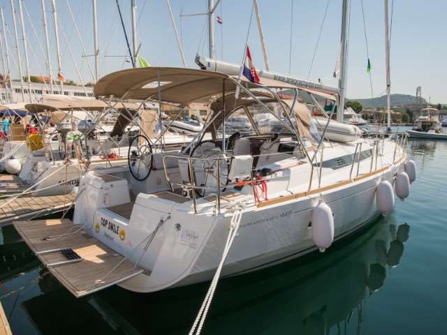 Jeanneau Sun Odyssey 449 2018 moored in a marina, showcasing elegant lines and spacious cockpit.