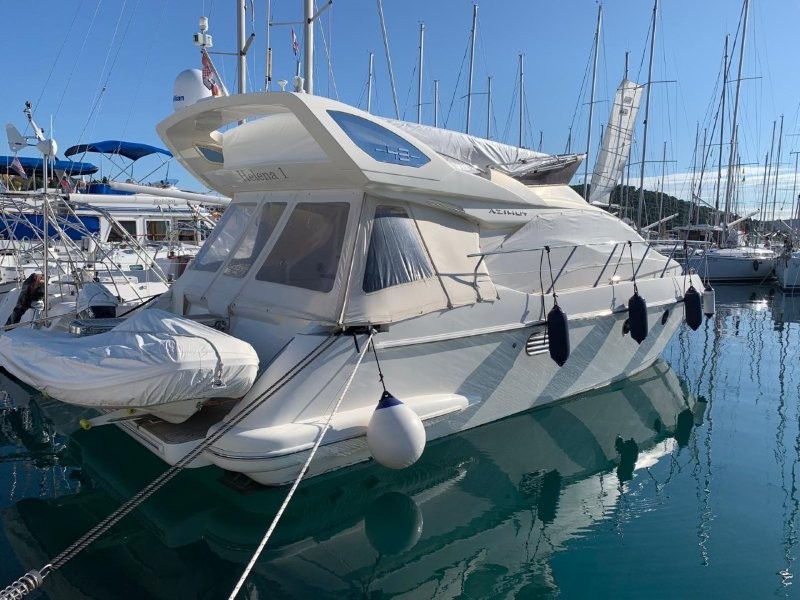 Elegant Azimut 43 2007 docked in a marina, showcasing its sleek profile and pristine hull.