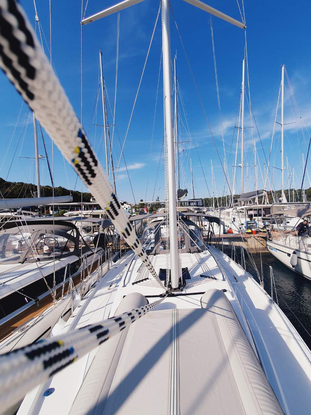 Infinity yacht docked at a bustling marina, showcasing its sleek lines and vibrant atmosphere.