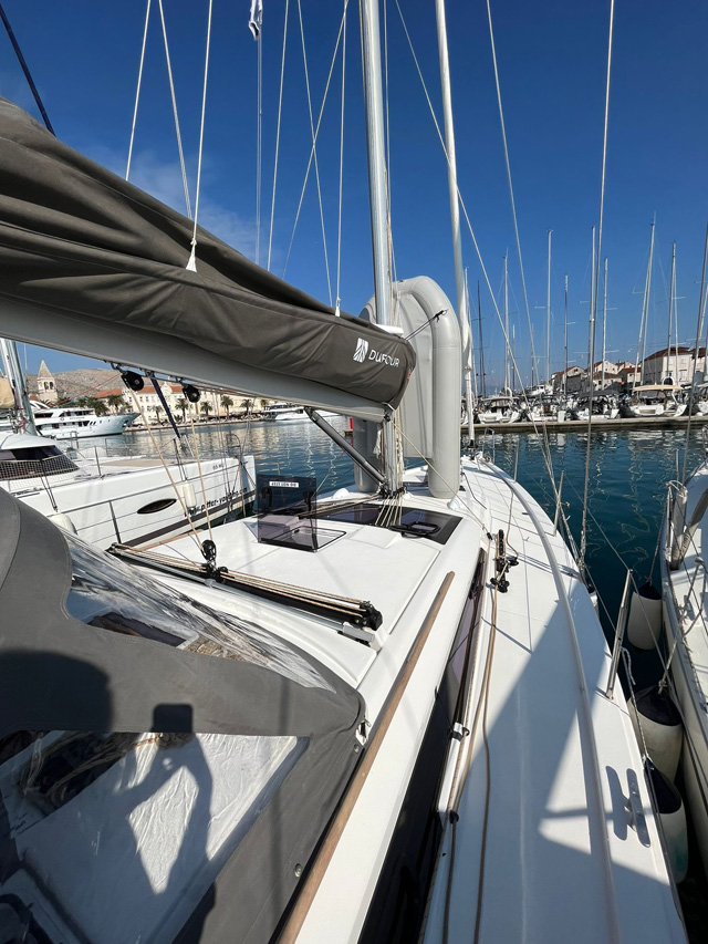 Sleek profile of Bella I at the marina, showcasing elegant lines and pristine deck space.