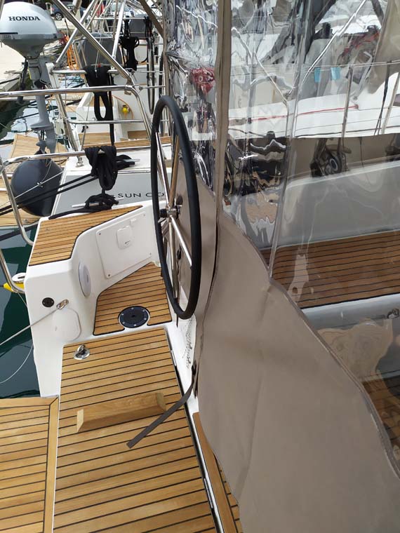 Sleek profile of Bright Elli showcasing polished teak deck and modern steering wheel.