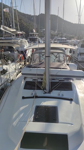 Gracia's sleek deck and mast showcase elegance in a bustling marina setting.
