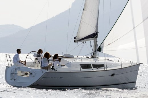 REGINA IV gracefully sailing with a sleek hull and billowing sails against a bright backdrop.