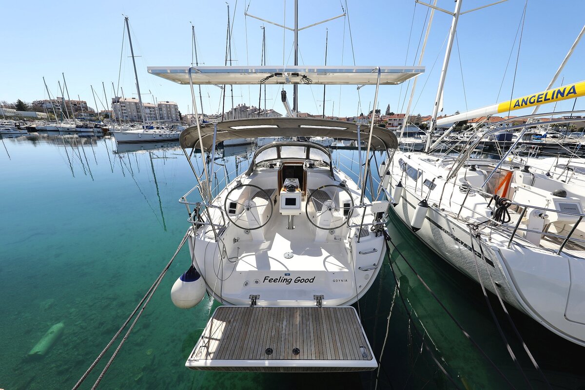 Sleek profile of Feeling Good docked in a serene marina, showcasing elegant lines and pristine hull.