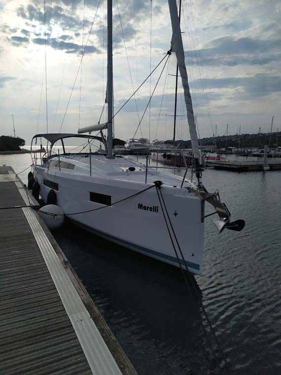 Sleek profile of Marelli docked, showcasing elegant lines and pristine hull in serene marina.