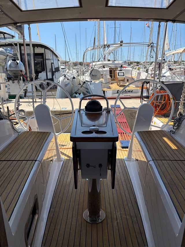 Spacious cockpit of Rocky III featuring elegant teak decking and modern helm controls.