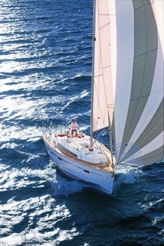 Elegant Hermes yacht sailing gracefully on sparkling blue waters, showcasing its sleek profile and vibrant sails.