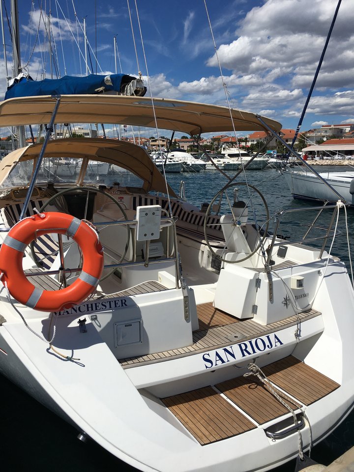 Spacious cockpit of San Rioja featuring elegant teak decking and modern steering controls.