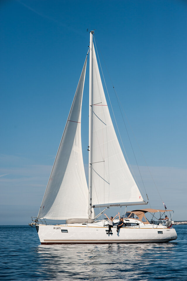 Sailing yacht No Limits gliding gracefully through calm waters under clear blue skies.