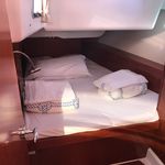 Cozy cabin aboard Spica featuring elegant wood finishes and soft bedding for relaxation.