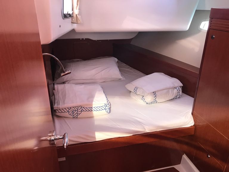 Cozy cabin aboard Spica featuring elegant wood finishes and soft bedding for relaxation.