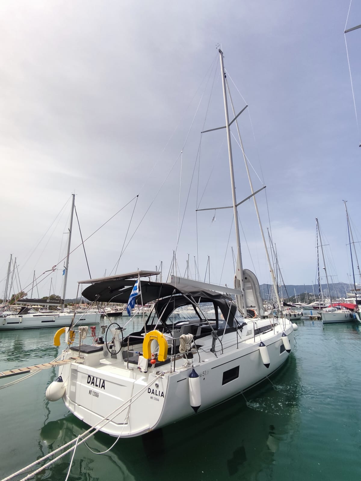 Sleek profile of Dalia docked in a vibrant marina, showcasing elegant lines and modern design.