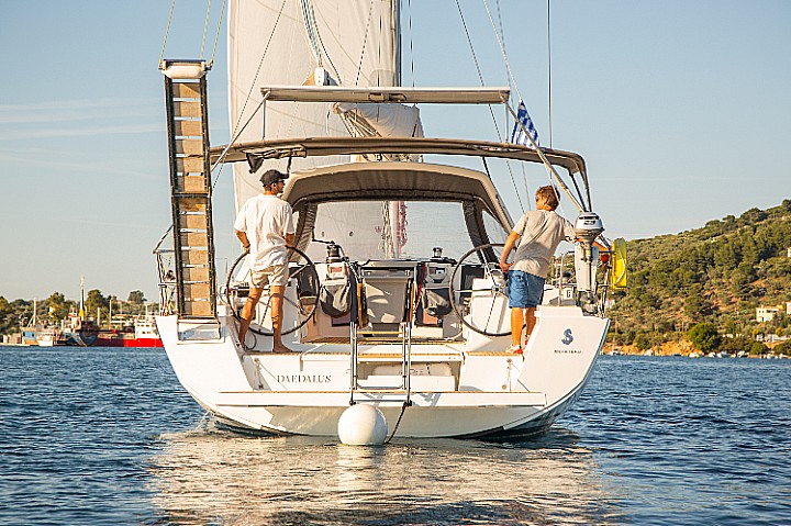 Daedalus gliding gracefully through calm waters with crew at the helm, showcasing elegant design.