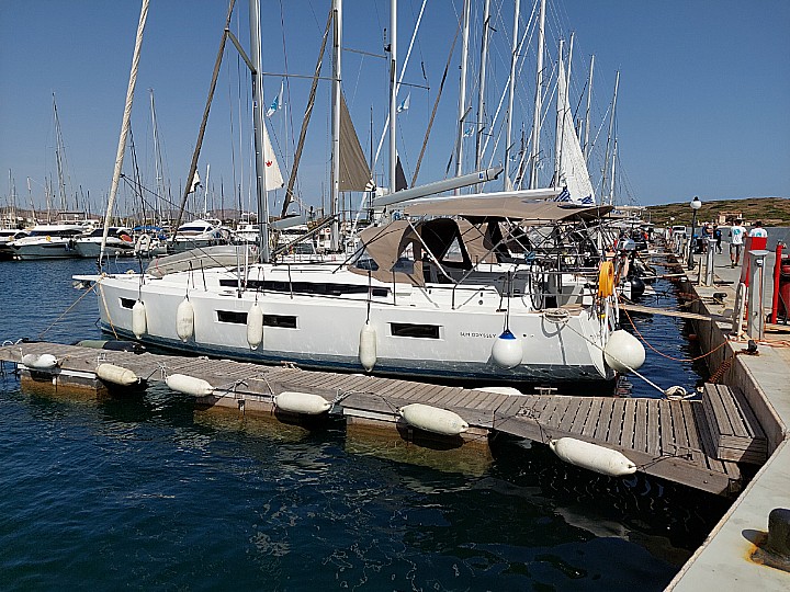 Olympia docked in a vibrant marina, showcasing its sleek hull and elegant design.
