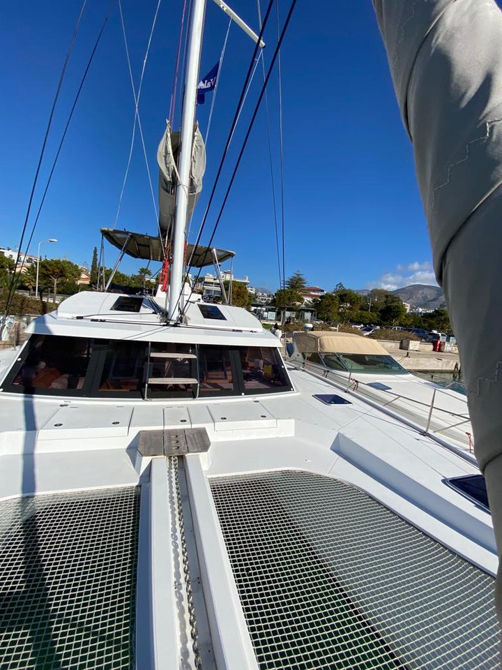 Sleek profile of Aureliano showcasing spacious deck and luxurious amenities under clear blue skies.