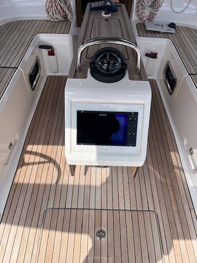 Sleek helm station on Amarone featuring modern navigation equipment and elegant teak flooring.
