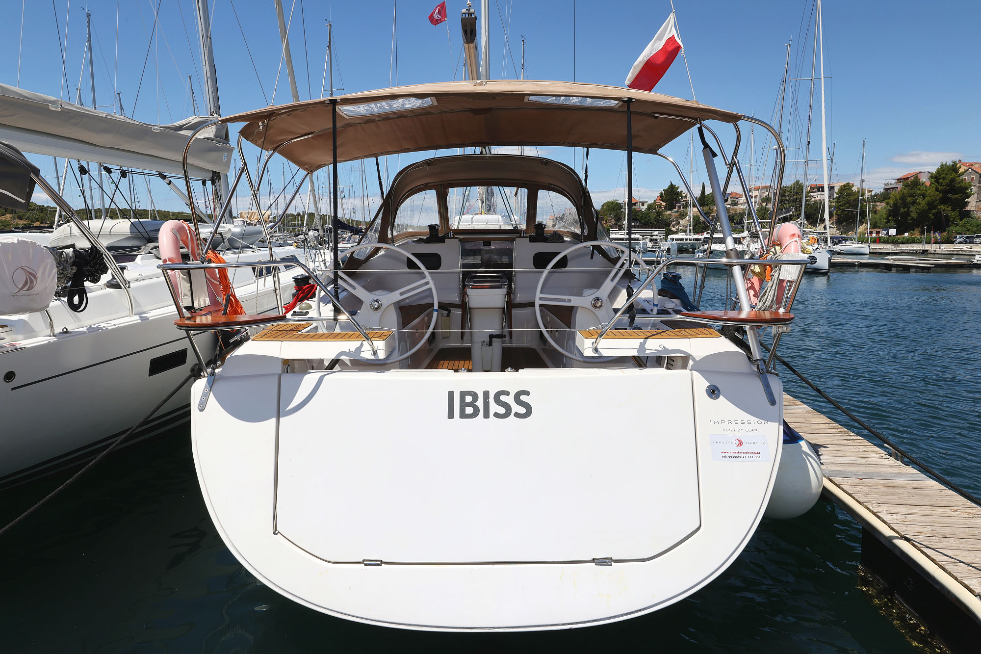 Sleek stern view of Ibiss showcasing elegant lines and inviting outdoor seating.