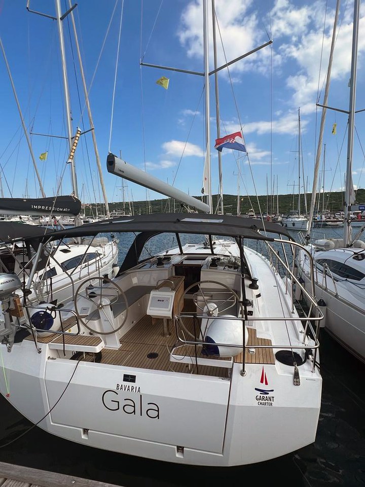 Sleek profile of the Gala yacht docked, showcasing its elegant design and spacious cockpit.