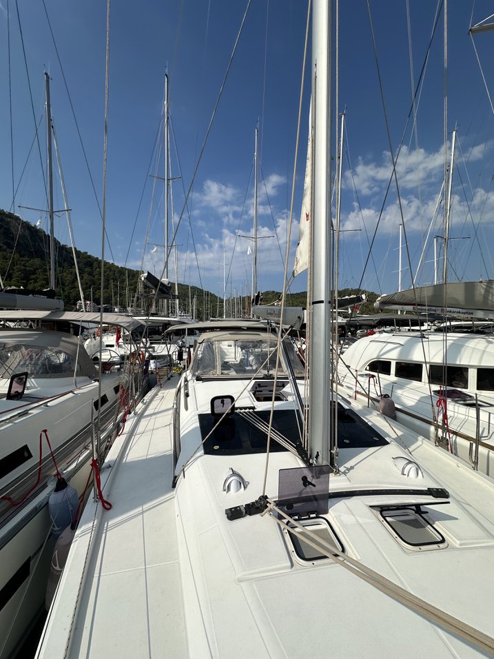 Sleek profile of Enki showcasing its elegant deck and mast against a clear blue sky.