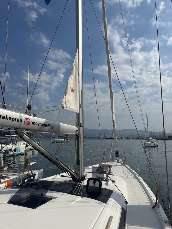 Sailing yacht Enki anchored in a serene marina, showcasing its elegant rigging and sails.