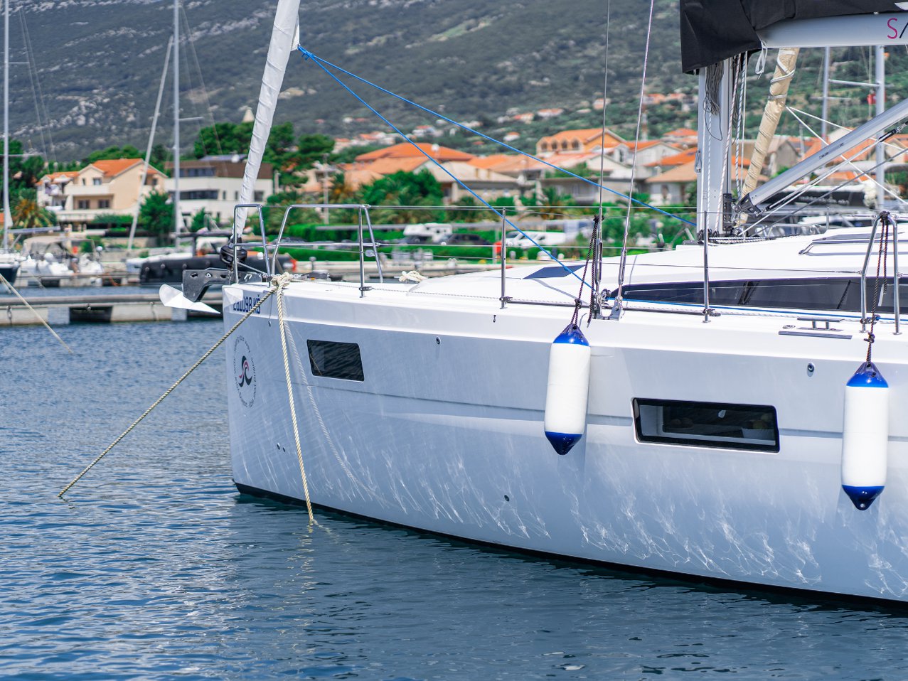 Sleek profile of Skipper's Girl docked in a picturesque marina, showcasing elegant lines and modern design.