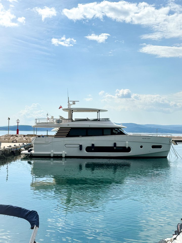 Moon Light anchored in a serene marina, showcasing its sleek profile and elegant design.