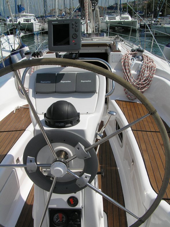 Sleek helm station of the Emanuel yacht, showcasing polished wood and modern navigation equipment.