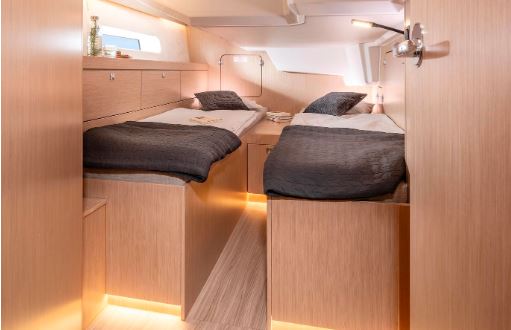 Luxurious twin cabin aboard Kebifaiv, featuring warm wood finishes and ambient lighting.