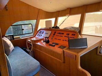 Sophisticated interior helm of Atil featuring warm wood finishes and modern navigation equipment.