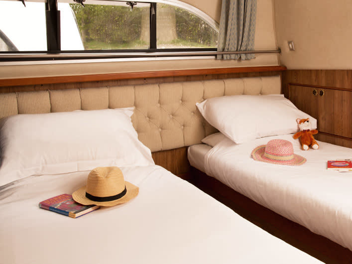 Elegant twin cabin aboard Clipper - Comfort 11, featuring plush bedding and natural light.