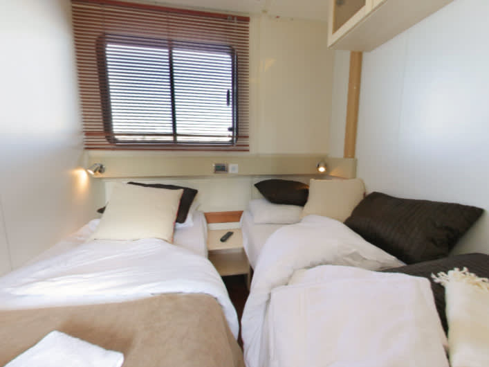 Luxurious twin cabin aboard Vision4 - Comfort Plus 5, featuring elegant textiles and natural light.