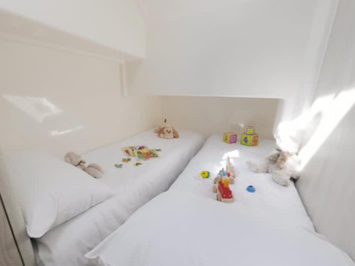 Bright and airy twin cabin on Horizon 2 - Premier 5, featuring soft linens and playful decor.