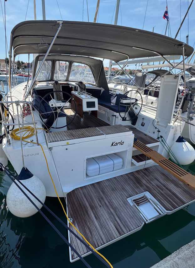 Elegant aft view of the Karla, showcasing its spacious cockpit and luxurious teak detailing.