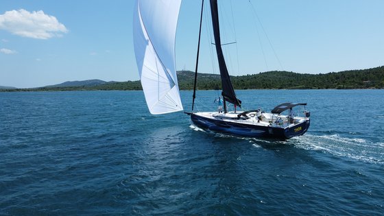 Sailing yacht Thor gliding smoothly through turquoise waters with billowing white sails.