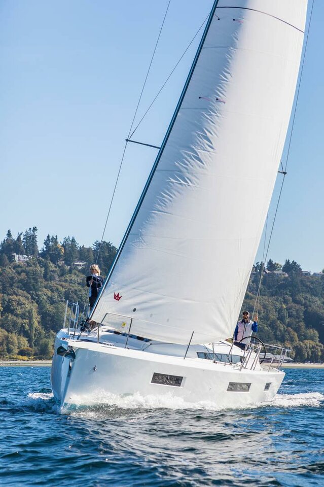Trinity sailing gracefully on open waters, showcasing its sleek hull and billowing sails.