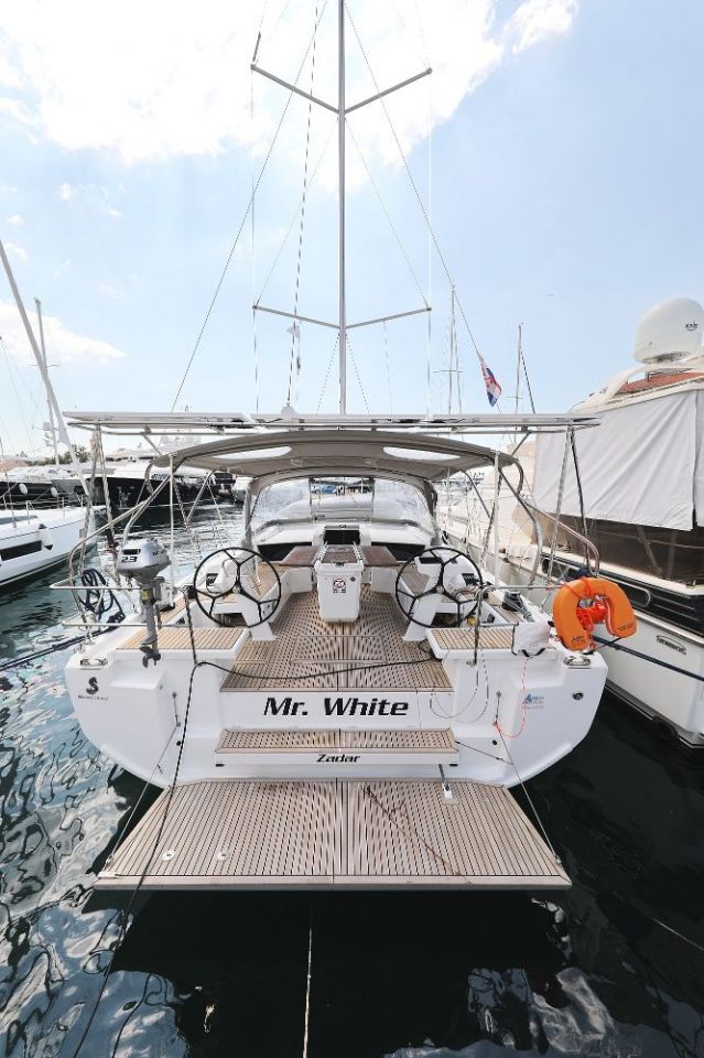 Elegant stern view of Mr. White showcasing sleek lines and luxurious seating in the marina.